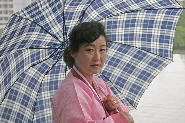 mulher-norte-coreana-segurando-um-guarda-chuva-azul
